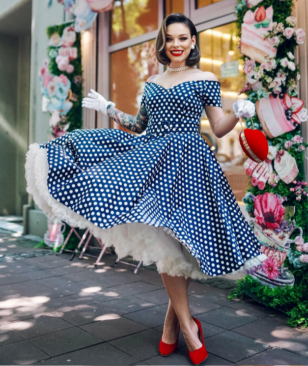 Vintage-style navy blue pin-up dress with white polka dots and petticoat